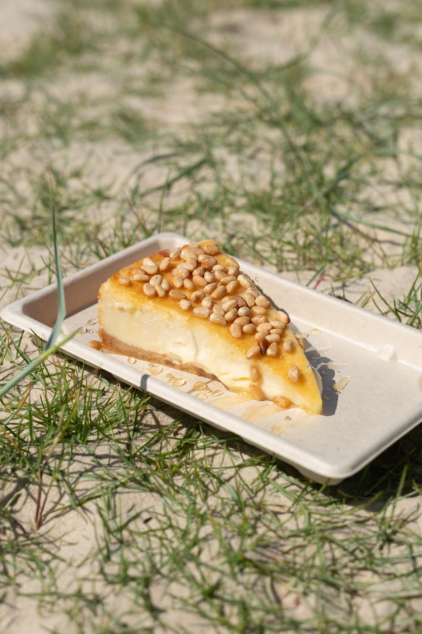 Porción de cheesecake Payoya, sobre la arena junto al mar.